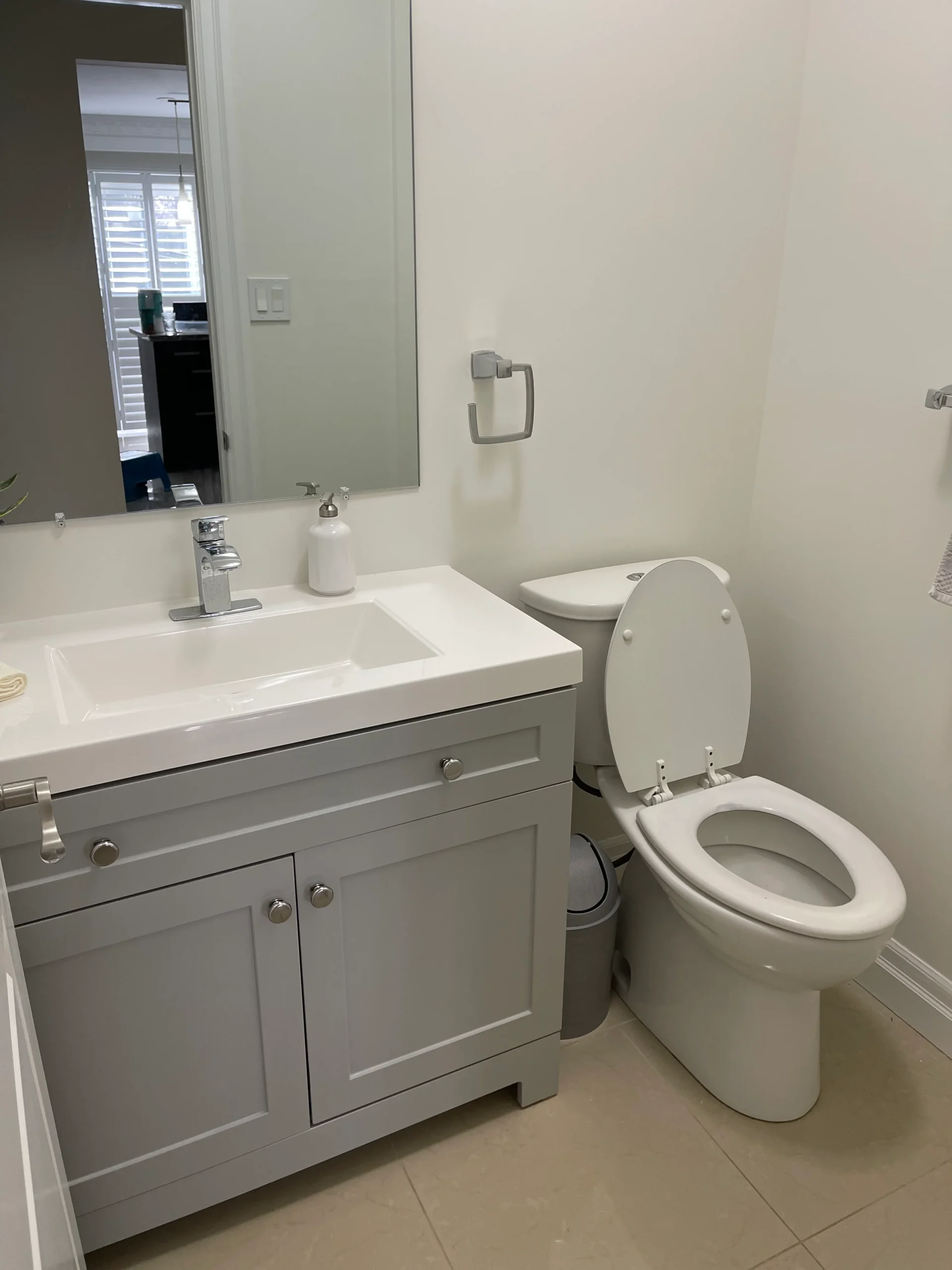 photo of small bathroom with white vanity sink mirror and toilet showing what is a powder room layout
