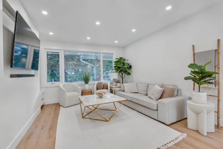 photo-of-modern-living-room-with-beige-sofa-glass-coffee-table-wall-mounted-tv-large-window-and-indoor-plants
