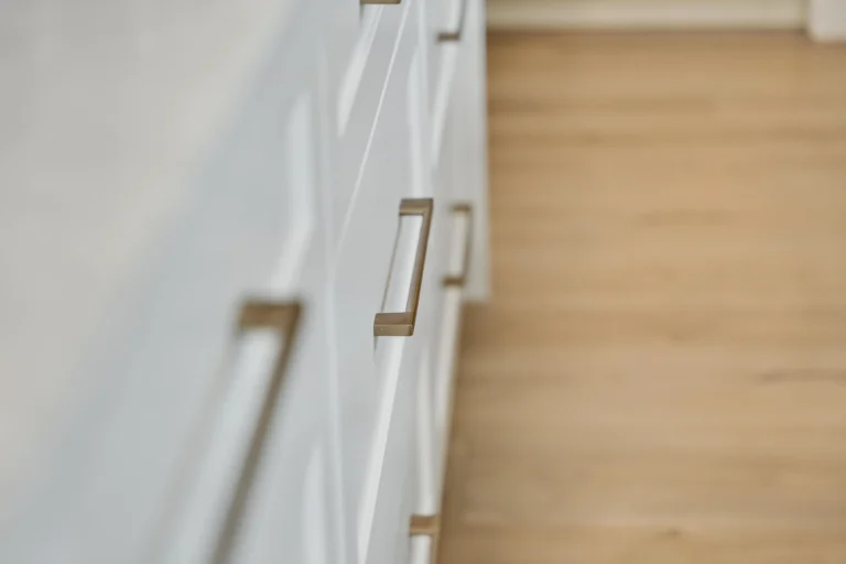 Photo brass cabinet handles on white kitchen drawers