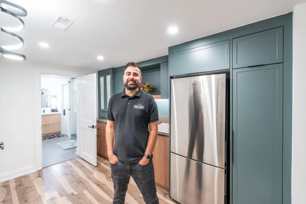 Photo contractor standing in renovated kitchen smiling