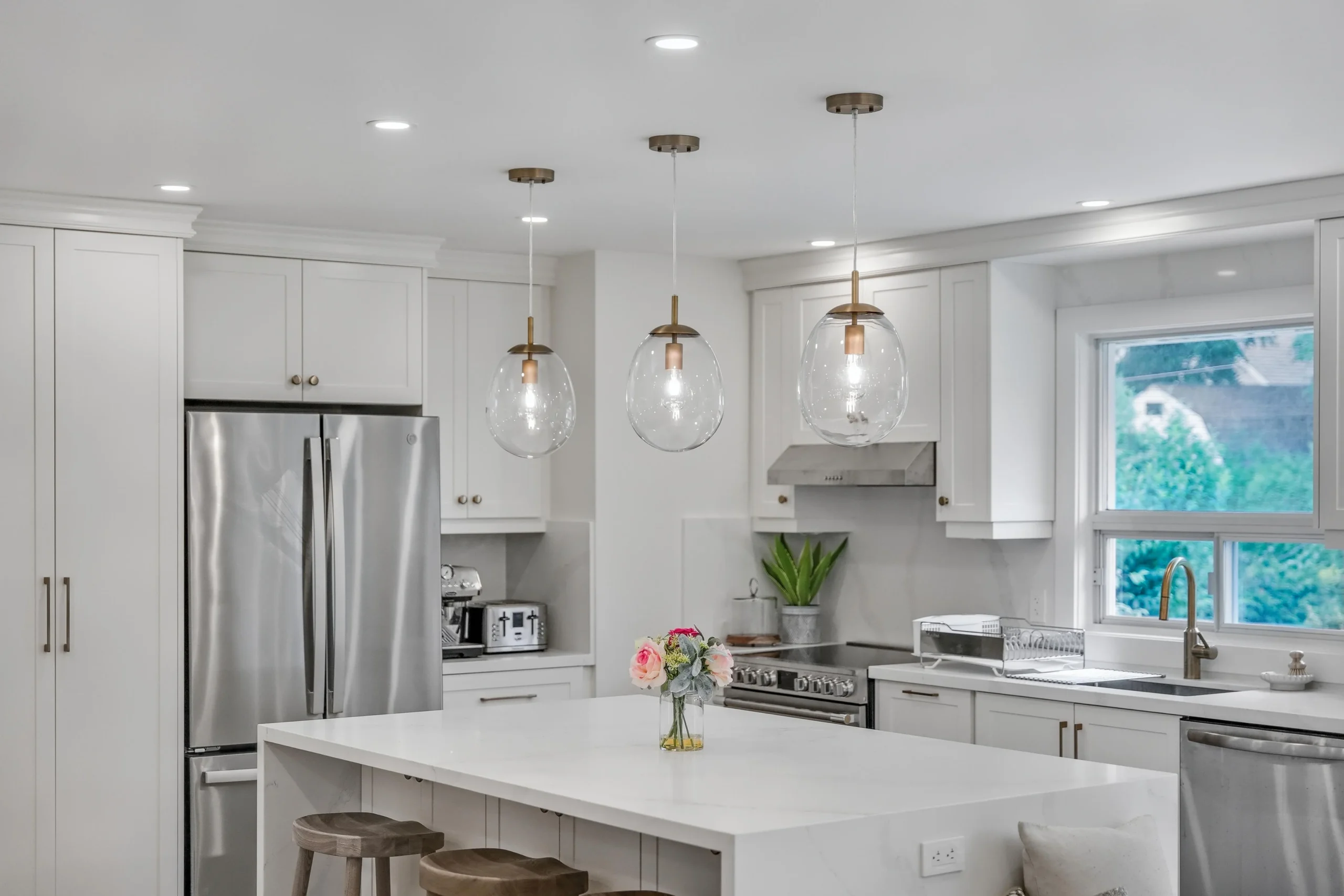 Photo of kitchen with glass pendant lights over island