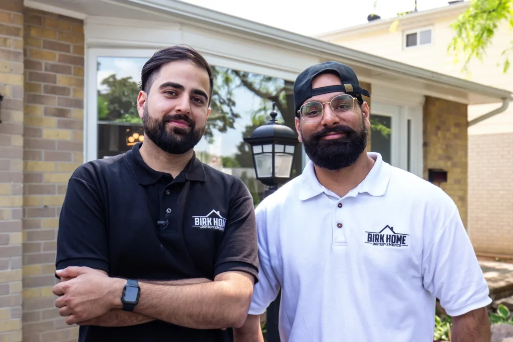 Photo two men in Birk Home shirts outside house