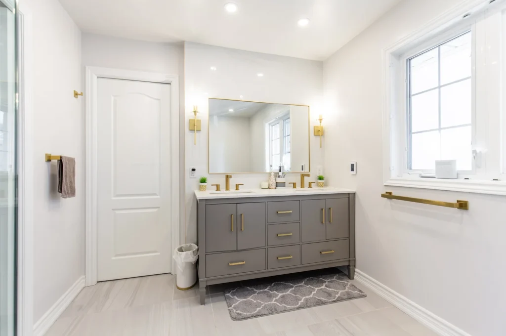 photo modern bathroom vanity with double sinks gold fixtures mirror window towel bars how to plan a bathroom renovation layout example (1)